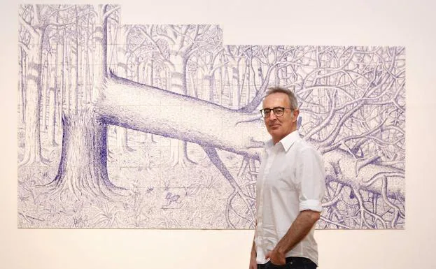 Jorge Fin, ayer en el Palacio Almudí junto a una de las obras de su exposición.