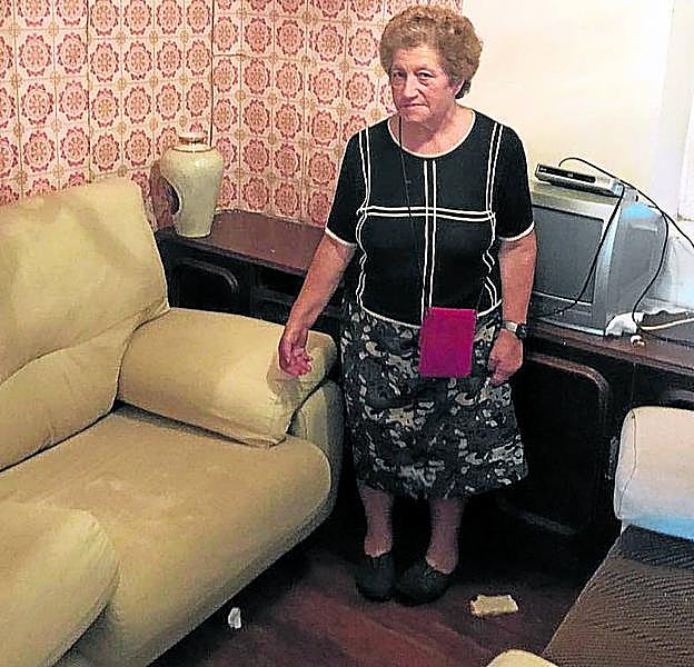 Una mujer muestra los daños en su piso recuperado de los okupas.