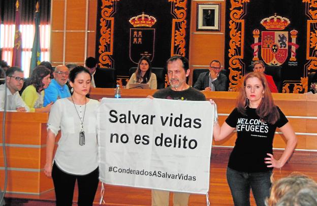 Tres activistas desplegaron una pancarta en el Pleno para apoyar a los bomberos de Lesbos.