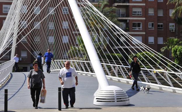 Varios ciudadanos, ayer, cruzando por la pasarela de Jorge Marinque.