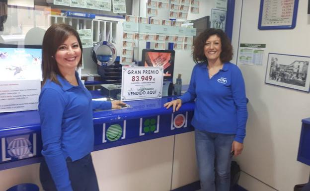 Dos trabajadoras posan con el cartel del premio.