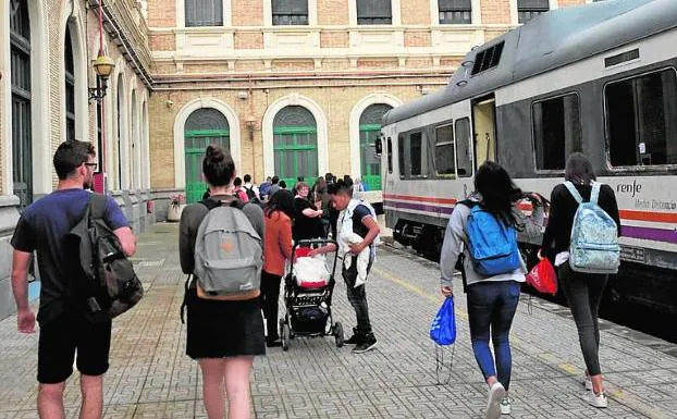 Los viajeros de un tren regional bajan en la estación.