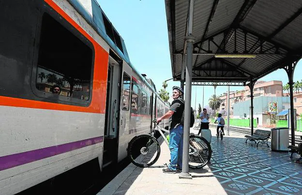 Un viajero sube con su bicicleta a un tren de cercanías, ayer, en la estación de Murcia.