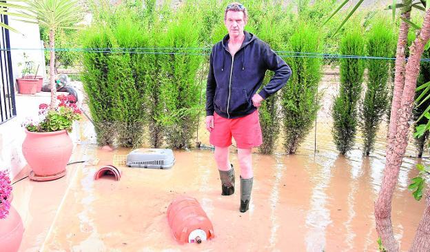 Robert Cox, en el jardín de su vivienda de Blanca, valorando los daños provocados por la inundación.