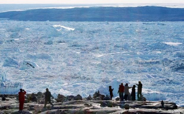 Turistas observan el hielo troceado de un iceberg en el fiordo de Ilulissat, en la costa de Groenlandia. 