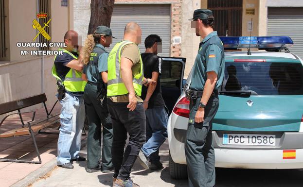 La Guardia Civil introduce a uno de los detenidos en un vehículo oficial.