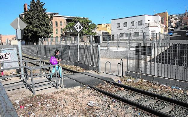 Una mujer cruza el paso a nivel de Los Mateos, en mayo.