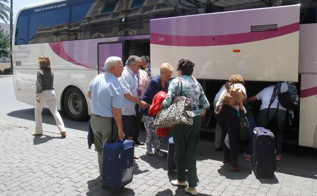 Pasajeros del tren Madrid-Cartagena, ayer, a su llegada en autobús a la estación de la Plaza de México. Abajo, mensaje enviado por Renfe a un usuario. 