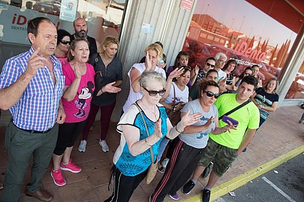 Un grupo de afectados protesta por el cierre de iDental frente a la puerta de la clínica de Cobatillas, el jueves por la mañana.