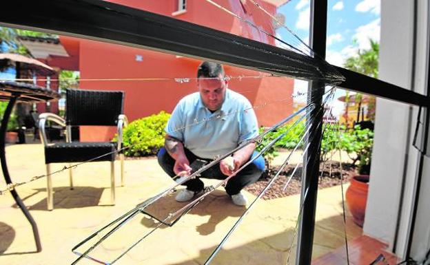 Pablo muestra los daños de una ventana de su chalé tras el último roce que tuvo con británicos.