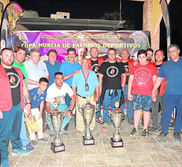 Los tres primeros de la Copa Murcia de colombicultura, con los árbitros y miembros federativos. 