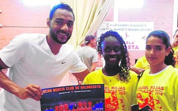 Sadiel Rojas, jugador del UCAM de la Liga Endesa y padrino del torneo de baloncesto de Secundaria, junto a dos jugadoras. 