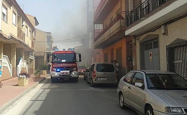 Un camión de bomberos junto a la vivienda incendiada.