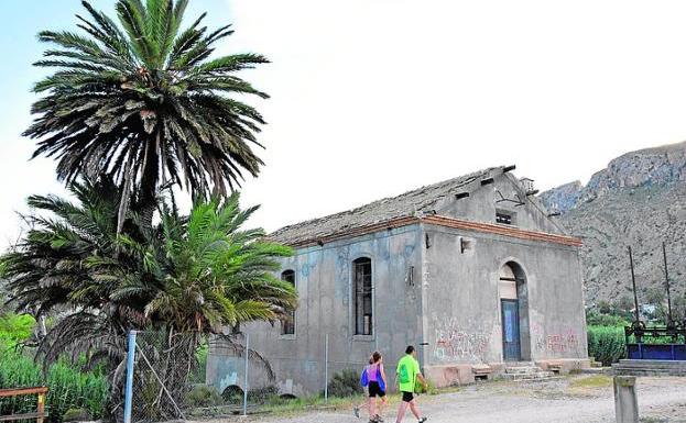 Dos vecinos pasean junto a la Fábrica de la Luz. 