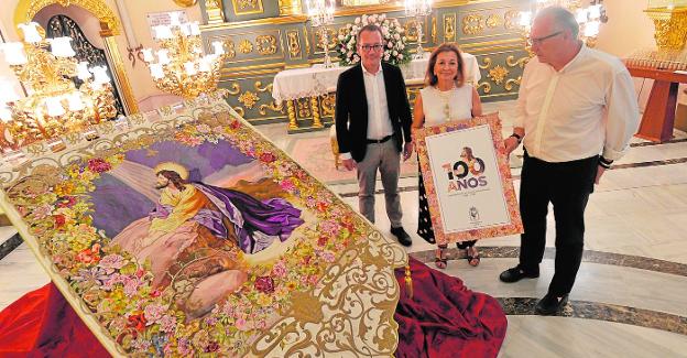 Ramón Mateos, Carmen García y Lázaro Soto, ayer, junto al estandarte de la Oración en el Huerto y el cartel del centenario. / agm