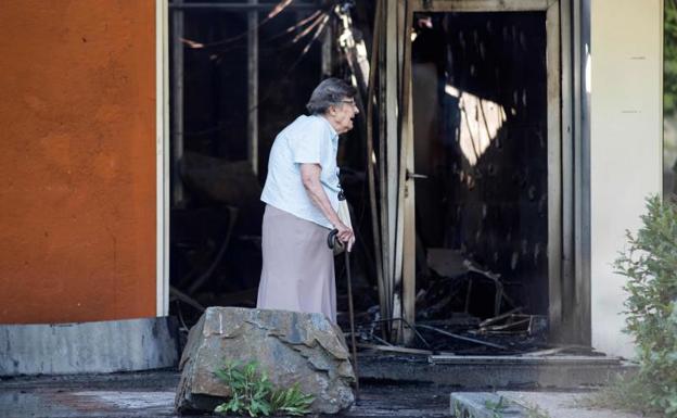 Una mujer pasea junto a uno de los establecimientos incendiados.