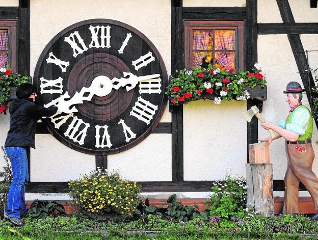 Una mujer cambia la hora en el reloj de cuco más grande del mundo en Schonach (Alemania). 