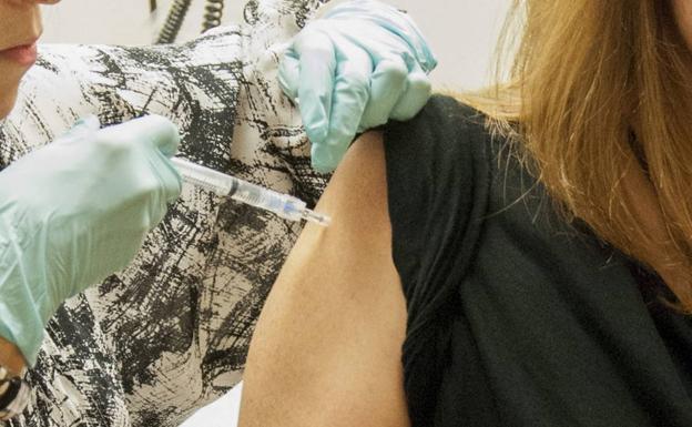Una mujer, recibiendo una vacuna.