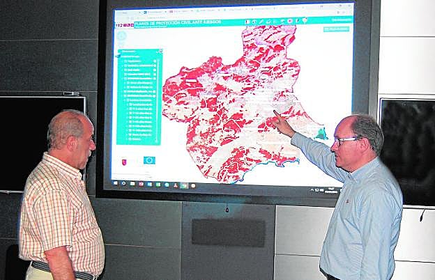 Alfonso Franco (i), técnico especialista del 112, y el director general de Emergencias, José Ramón Carrasco, explicando el funcionamiento del visor. 