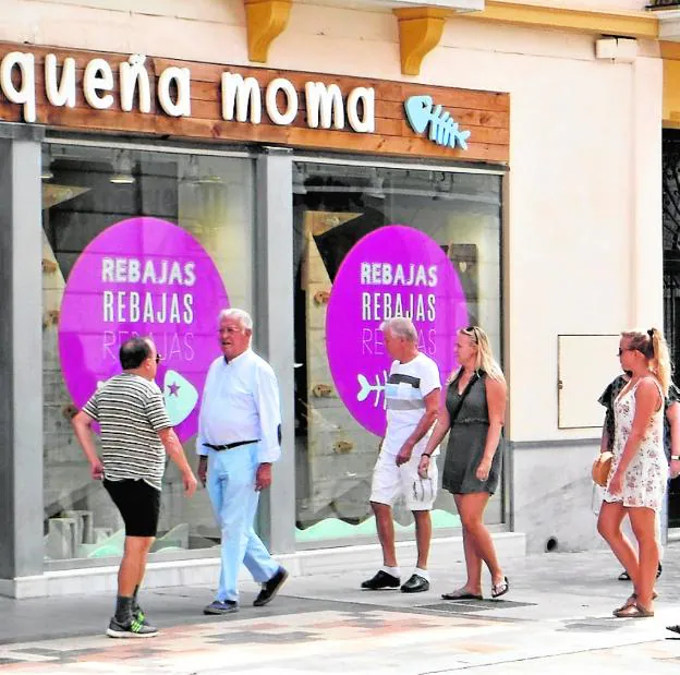 Viandantes pasan frente a un comercio del centro. 