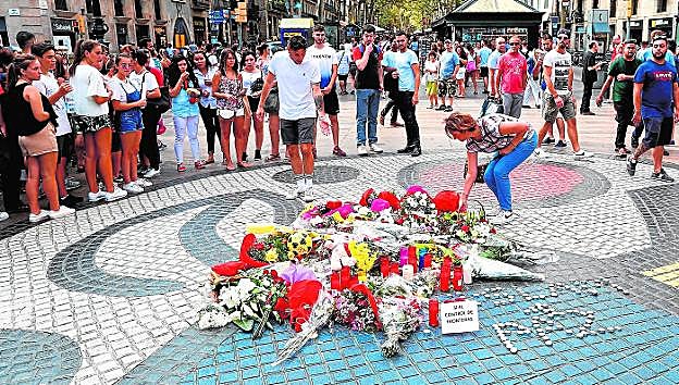 Ramos de flores y objetos de todo tipo depositados en el mural de Miró de La Rambla. 
