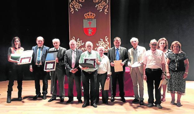 Los homenajeados muestran sus placas. 