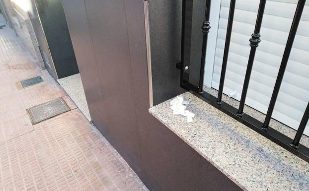 La ventana de la vivienda, con los guantes empleados por la Policía Científica.