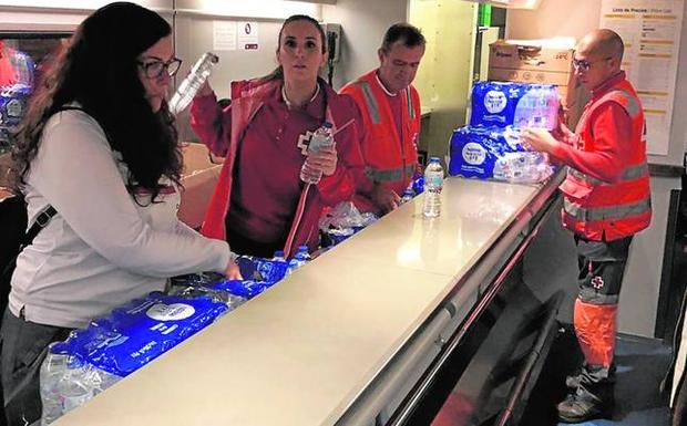 Miembros de Cruz Roja preparan el agua para repartir a los pasajeros en el tren Talgo. 