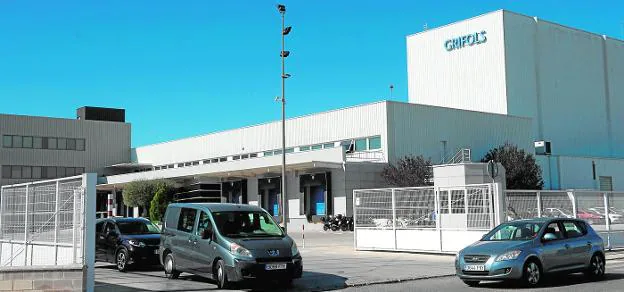 Varios vehículos salen, ayer, de la planta que la empresa Grifols tiene en el polígono de Los Llanos, en Las Torres de Cotillas. 