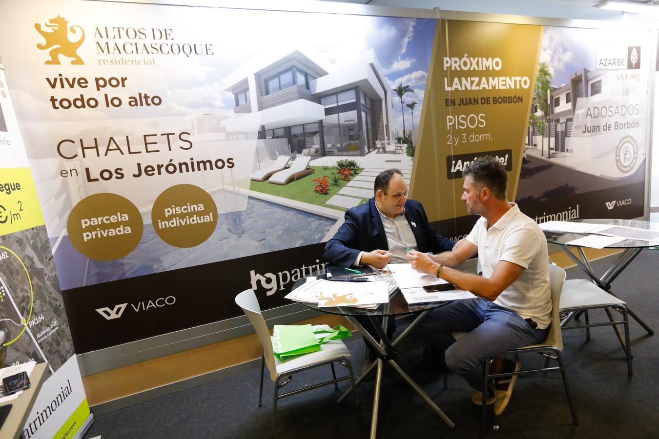 Varios clientes son atendidos en expositores de promotoras en la feria inmobiliaria 'Reside 2018' en el Hotel NH Amistad