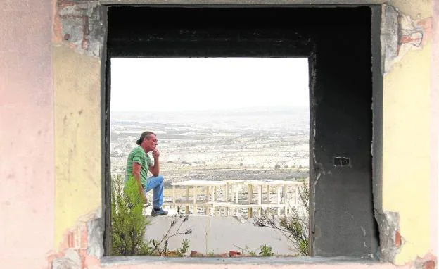 Antonio Martínez, visto a través de la ventana de una de las casas piloto que construyó en Campos del Río. 