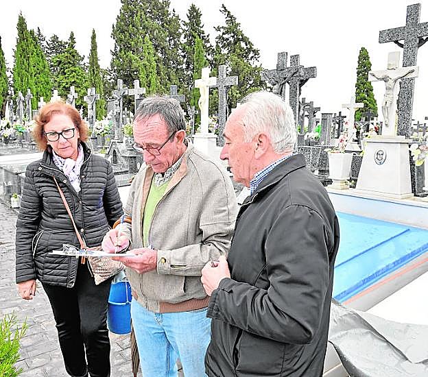 José Martínez (d) observa cómo Sebastián firma el escrito.