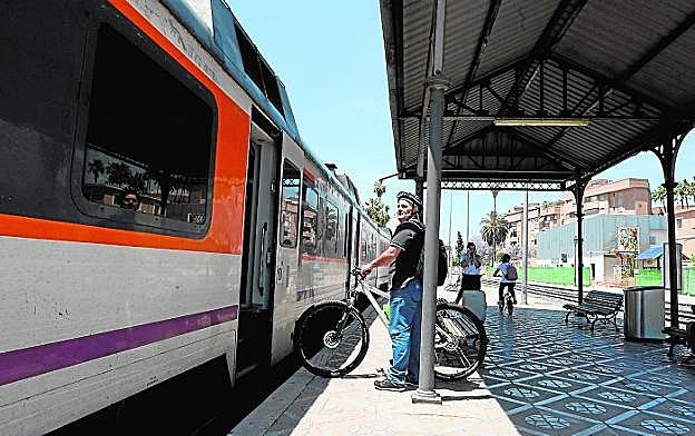 Un viajero sube con su bicicleta a un tren de Cercanías, en la estación de Murcia. 