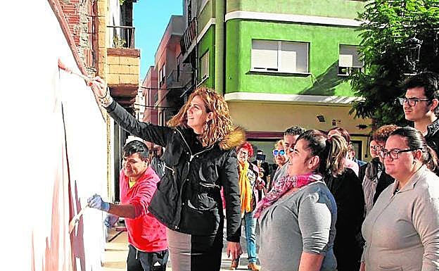 La alcaldesa pinta un mural con los usuarios del centro de día. 