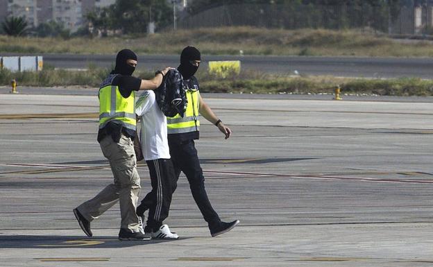 La policía española escoltan a un hombre, sospechoso de reclutar mujeres para el grupo yihadista armado Estado Islámico.