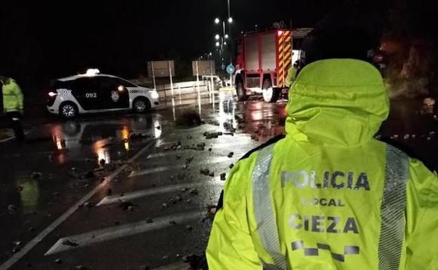 Imagen principal - Rastros de la lluvia en Cieza: 1. Desprendimiento de piedras en una carretera. 2. Cultivos anegados. 3. Un tapa de alcantarillado desbordada.