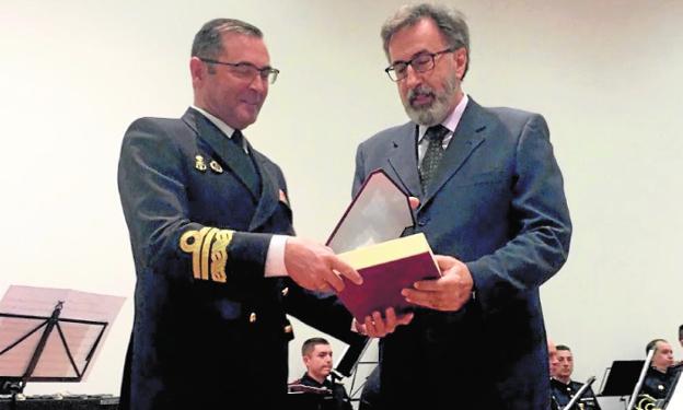 Manuel de la Puente, almirante de Acción Marítima, a la izquierda, recibe la placa de socio de honor de mano de Horacio Sánchez, presidente del Club de Regatas de Santiago de la Ribera. 