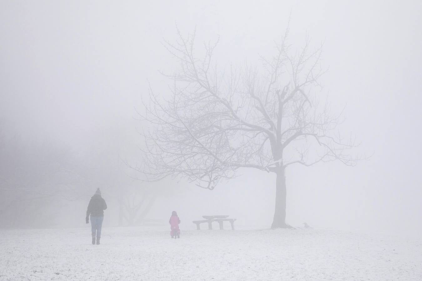 Varias personas pasean sobre la nieve en la colina de Buda en Budapest (Hungría), donde el frío ha llegado para quedarse.