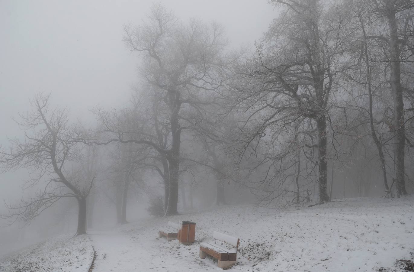 Varias personas pasean sobre la nieve en la colina de Buda en Budapest (Hungría), donde el frío ha llegado para quedarse.