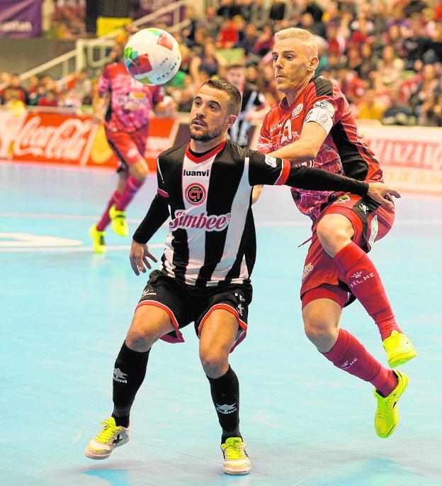 Miguelín defiende a Juanpi, exjugador de ElPozo, en una acción del derbi disputado ayer en el Palacio. 