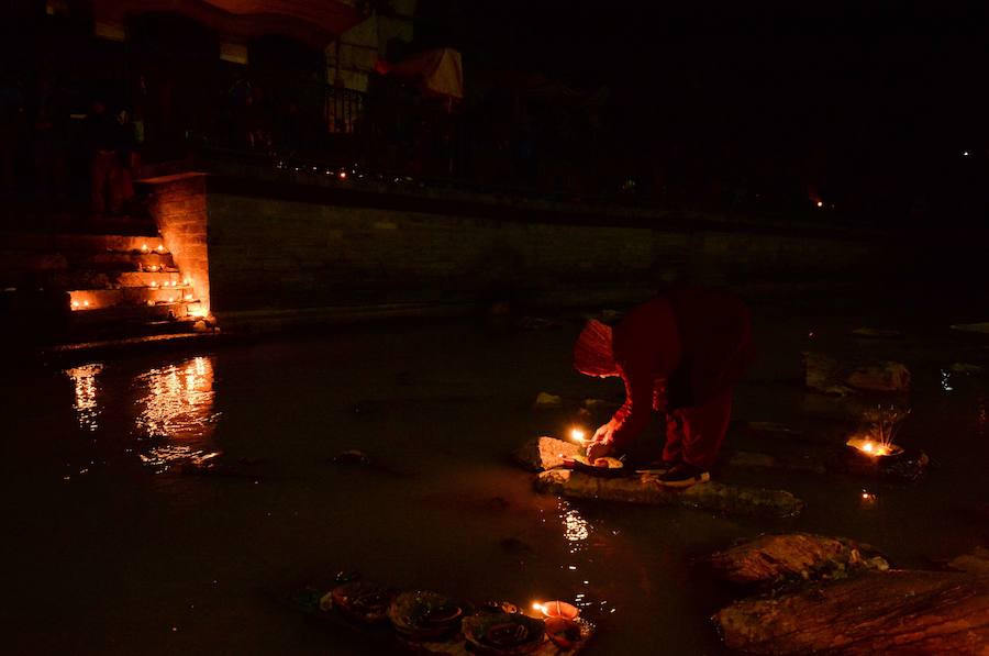 Los fieles hindúes nepalíes encienden lámparas de aceite y siembran siete tipos de semillas alrededor de las instalaciones del templo en nombre de los familiares difuntos.