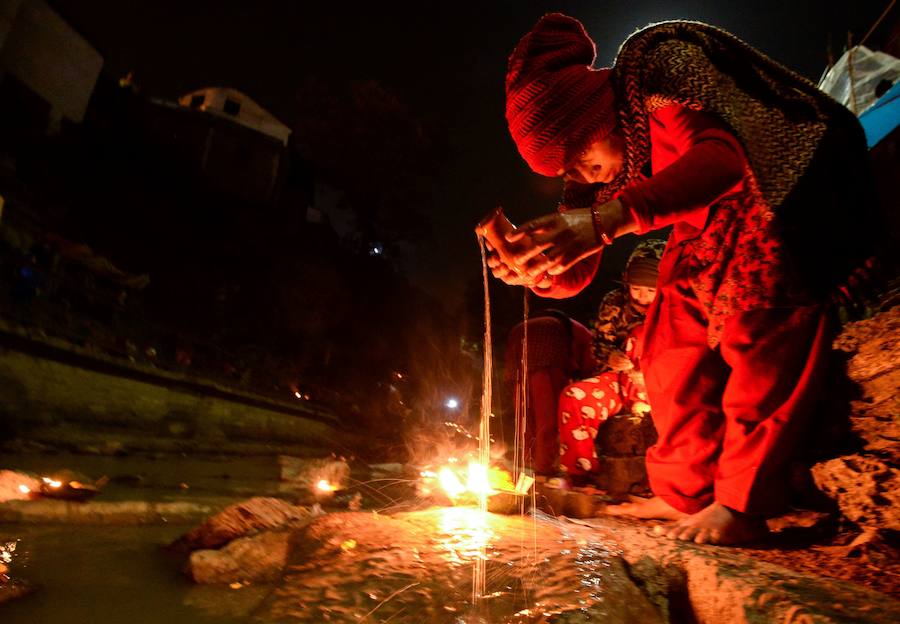 Los fieles hindúes nepalíes encienden lámparas de aceite y siembran siete tipos de semillas alrededor de las instalaciones del templo en nombre de los familiares difuntos.