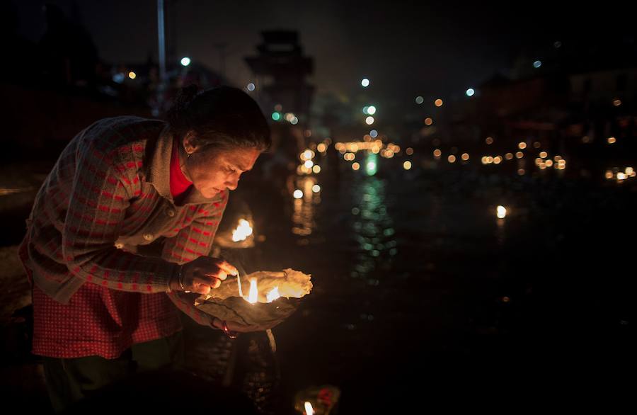 Los fieles hindúes nepalíes encienden lámparas de aceite y siembran siete tipos de semillas alrededor de las instalaciones del templo en nombre de los familiares difuntos.