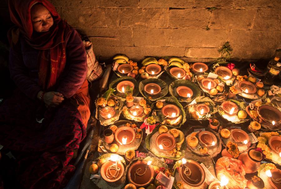 Los fieles hindúes nepalíes encienden lámparas de aceite y siembran siete tipos de semillas alrededor de las instalaciones del templo en nombre de los familiares difuntos.