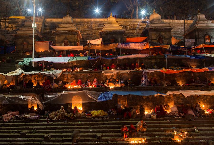 Los fieles hindúes nepalíes encienden lámparas de aceite y siembran siete tipos de semillas alrededor de las instalaciones del templo en nombre de los familiares difuntos.