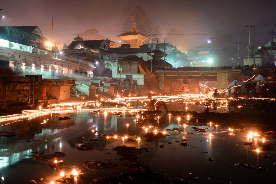 Los fieles hindúes nepalíes encienden lámparas de aceite y siembran siete tipos de semillas alrededor de las instalaciones del templo en nombre de los familiares difuntos.