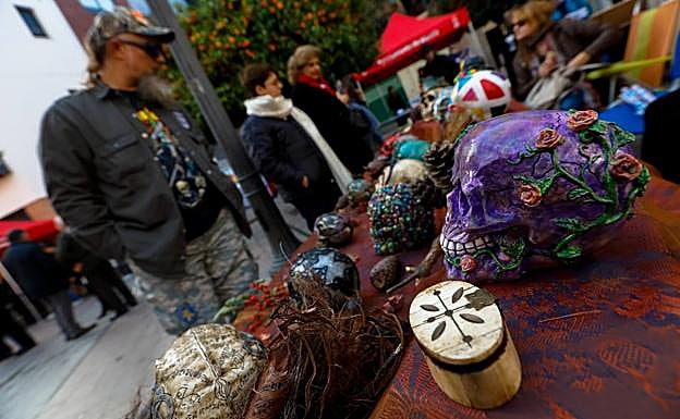 Un visitante observa algunas piezas de artesanía.