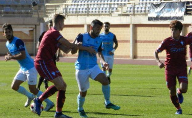 Edu Luna, central del Jumilla, pugna por un balón con un jugador del CD Ejido.