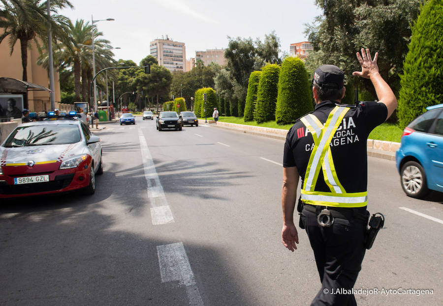 Un agente de la Policía Local de Cartagena da el alto a un vehículo.