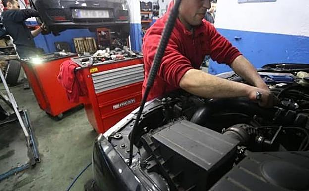 Un mecánico repara un vehículo.